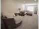 Cozy living room featuring an accent chair, plush sectional sofa, neutral color palette, and ample natural light at 14572 Black Quill Dr, Winter Garden, FL 34787