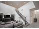 Comfortable living room with a gray couch and stylish staircase leading upstairs at 14572 Black Quill Dr, Winter Garden, FL 34787