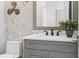 Neutral powder room with modern fixtures, grey vanity, and herringbone patterned accent wall at 1613 Bellagio Loop, Tavares, FL 32778