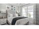 Comfortable bedroom with shiplap accent wall, large window, and patterned curtains at 1613 Bellagio Loop, Tavares, FL 32778