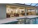 Covered patio featuring outdoor seating, dining area, and a built-in grill overlooking the refreshing pool area at 1613 Bellagio Loop, Tavares, FL 32778
