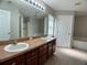 Bathroom with double sinks, a large mirror, and ample cabinet space at 1715 Redfin Way, Kissimmee, FL 34759