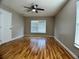 Cozy bedroom featuring hardwood floors, a ceiling fan, and a large window at 1715 Redfin Way, Kissimmee, FL 34759