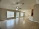 Spacious living area featuring tile floors, ceiling fan, and access to the kitchen at 1715 Redfin Way, Kissimmee, FL 34759