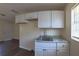 Kitchenette featuring white cabinets and counters, with a sink and faucet at 2031 Warrens Ave, Maitland, FL 32751