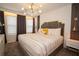 The bedroom is bright with natural light, featuring modern light fixture, padded headboard and neutral decor at 2379 Distant Sun Trl, Kissimmee, FL 34747