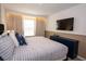 Comfortable bedroom featuring a plush bed, flat screen TV, and stylish decor at 2379 Distant Sun Trl, Kissimmee, FL 34747