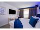 Charming bedroom featuring themed decor, a plush bed, and a sleek entertainment center at 2379 Distant Sun Trl, Kissimmee, FL 34747