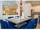 Dining area with blue velvet chairs, modern table setting, and reflected view of kitchen at 2379 Distant Sun Trl, Kissimmee, FL 34747