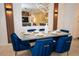 Dining area featuring a modern table set with blue velvet chairs, a mirror, and stylish decor at 2379 Distant Sun Trl, Kissimmee, FL 34747