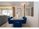 Dining area with a sleek table, plush blue chairs, and modern light fixtures at 2379 Distant Sun Trl, Kissimmee, FL 34747