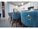 Close up of seating at a kitchen island with a view of white cabinets at 2379 Distant Sun Trl, Kissimmee, FL 34747