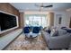 Stylish living room featuring modern decor, a comfortable couch, and access to a screened-in pool area at 2379 Distant Sun Trl, Kissimmee, FL 34747