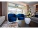 Bright living room with blue velvet chairs and a view of the screened-in pool area at 2379 Distant Sun Trl, Kissimmee, FL 34747