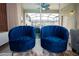 Close up of two blue chairs looking onto a screened in pool area at 2379 Distant Sun Trl, Kissimmee, FL 34747