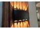 A modern wall sconce casts a warm glow on the textured wooden paneling, highlighting its detail at 2379 Distant Sun Trl, Kissimmee, FL 34747