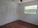 Bedroom with a window, wood floors, and a closet with bi-fold doors at 2632 Derbyshire Rd, Maitland, FL 32751