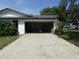 Spacious attached garage with an open door and concrete driveway at 2632 Derbyshire Rd, Maitland, FL 32751