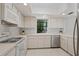 Well-lit kitchen with white appliances, cabinets and a window overlooking the landscaped backyard at 2652 Bent Hickory Cir, Longwood, FL 32779
