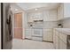 Bright kitchen featuring white appliances and cabinets, complemented by tile flooring and modern fixtures at 2652 Bent Hickory Cir, Longwood, FL 32779