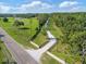 A long, gated driveway leads to a private property surrounded by lush greenery, seen from an aerial view at 2659 Hibbard Trl, Chuluota, FL 32766