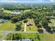 An aerial view showcases a home with lush greenery, mature trees, and a long driveway at 2659 Hibbard Trl, Chuluota, FL 32766