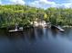 Aerial view showcasing the lakefront property with a private dock, a boat canopy and lush trees at 2659 Hibbard Trl, Chuluota, FL 32766