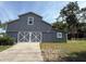 Spacious gray barn with double doors, offering ample storage or workshop potential on the property at 2659 Hibbard Trl, Chuluota, FL 32766