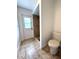 Bathroom featuring a door to the exterior, a toilet, and a tiled shower at 2659 Hibbard Trl, Chuluota, FL 32766