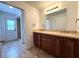 Bathroom with a double vanity and door leading to the tiled shower at 2659 Hibbard Trl, Chuluota, FL 32766