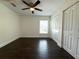 Bedroom with dark wood floors, ceiling fan, and double-door closet at 2659 Hibbard Trl, Chuluota, FL 32766