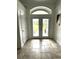 Bright entryway featuring tiled flooring, double glass doors with transom window, and neutral walls at 2659 Hibbard Trl, Chuluota, FL 32766