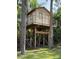 Charming elevated treehouse with a ladder and deck, offering a playful retreat in the trees at 2659 Hibbard Trl, Chuluota, FL 32766