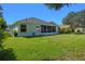Well-maintained backyard with green lawn, screened in patio and lush surroundings, perfect for outdoor relaxation at 2710 Autumn Ln, Eustis, FL 32726