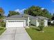 Inviting exterior featuring a two-car garage, well-kept lawn, and neatly landscaped garden at 2710 Autumn Ln, Eustis, FL 32726