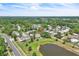 An aerial view of a residential neighborhood featuring a pond and tree-lined streets at 283 Woodgreen Ln, Winter Springs, FL 32708