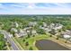 An aerial view of a residential neighborhood featuring a pond and tree-lined streets at 283 Woodgreen Ln, Winter Springs, FL 32708