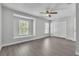 Well-lit bedroom boasts wood-look flooring, a ceiling fan, and large windows with views at 283 Woodgreen Ln, Winter Springs, FL 32708