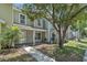 Charming two-story home with a sidewalk leading to the front door and a mature tree providing shade at 283 Woodgreen Ln, Winter Springs, FL 32708