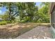 Spacious backyard offers shade trees, a brick patio, and leisure areas perfect for relaxation at 3007 Huntington St, Orlando, FL 32803