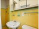 Bathroom boasts vintage yellow and green tile, a pedestal sink, and mirrored medicine cabinet at 3007 Huntington St, Orlando, FL 32803