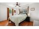 Cozy bedroom with a ceiling fan, hardwood floors, and natural light from the large windows at 3007 Huntington St, Orlando, FL 32803