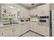 Well-lit kitchen featuring white cabinetry, essential appliances, and tiled flooring for easy maintenance at 3007 Huntington St, Orlando, FL 32803