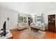 Cozy living room with hardwood floors, comfortable seating, large windows with drapes, and built-in bookshelves at 3007 Huntington St, Orlando, FL 32803
