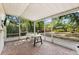 Relaxing screened-in porch with brick flooring offers an outdoor dining area and views of the lush backyard at 3007 Huntington St, Orlando, FL 32803