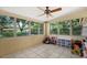 Bright sunroom surrounded by windows, ceramic tile flooring, and a ceiling fan at 3007 Huntington St, Orlando, FL 32803