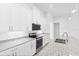 Modern kitchen with white cabinets, granite countertops, and stainless steel appliances at 304 N Jungle Rd, Geneva, FL 32732