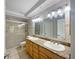 Bathroom featuring double sinks, granite countertops, and a tiled shower at 306 Foxboro Ct, Lake Mary, FL 32746