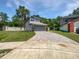 Charming home with a well-manicured lawn, brick driveway, and tropical landscaping at 306 Foxboro Ct, Lake Mary, FL 32746