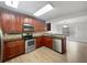 Modern kitchen features stainless steel appliances, granite countertops, and wood cabinets, and flows into the dining area at 306 Foxboro Ct, Lake Mary, FL 32746